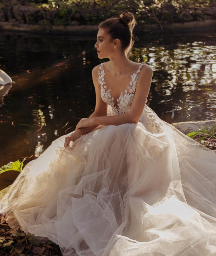 Photo of the model wearing a white bridal gown near the lake